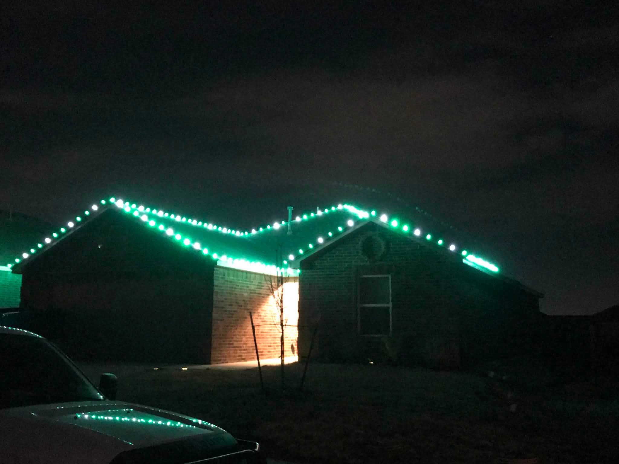 Brick house with green and white roofline lights